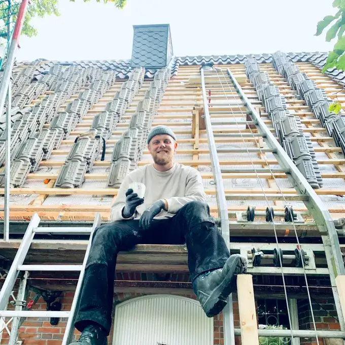 Dachdeckermeister Anton Krüger auf dem Gerüst bei einer Dachneueindeckung