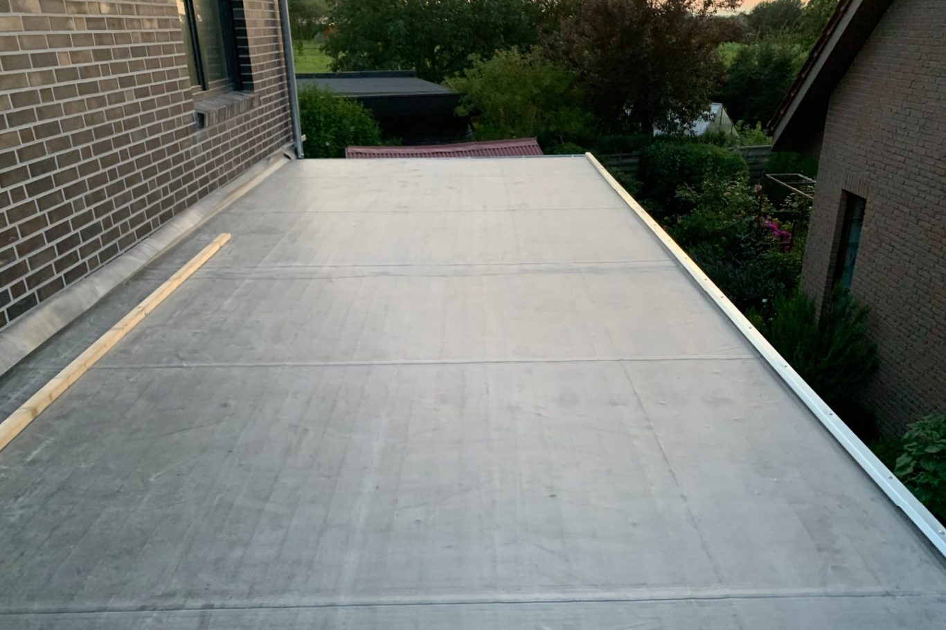 Dachfläche mit Betonbelag, umgeben von Häusern